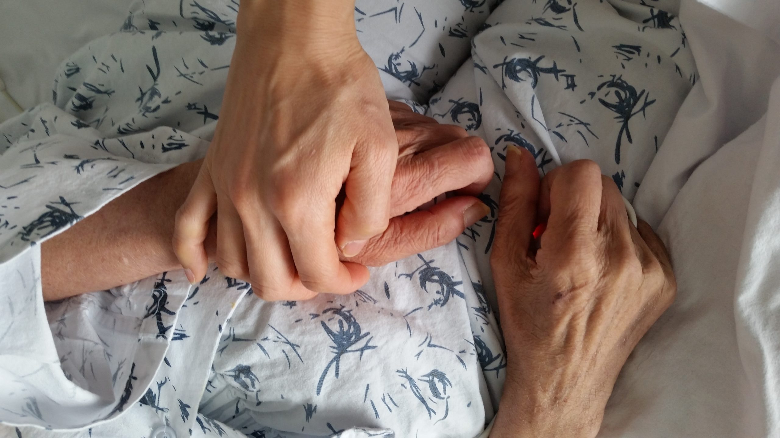 holding-elderly-family-members-hand-in-hospital-during-end-of-life-care_t20_roJeLd